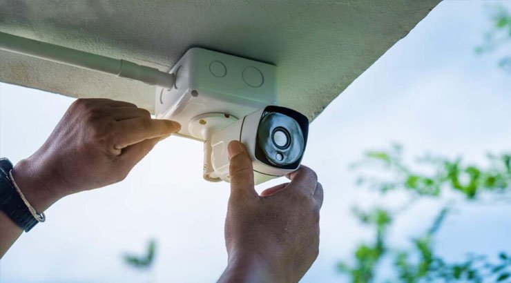 Technician installing a security camera on a commercial building in Uganda, Security camera installation in Uganda